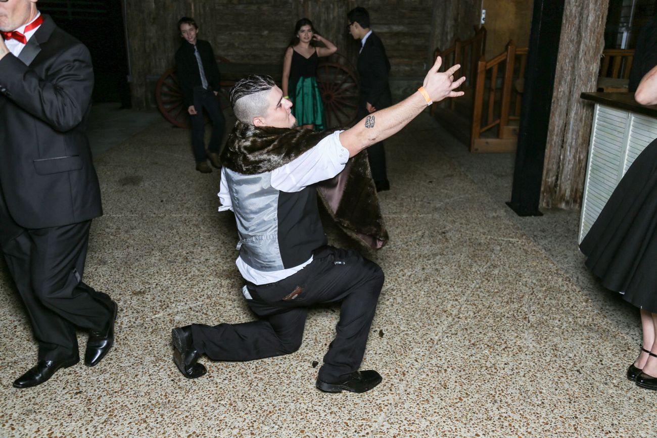 A guest down on one knee, arm flung out, mid-dance