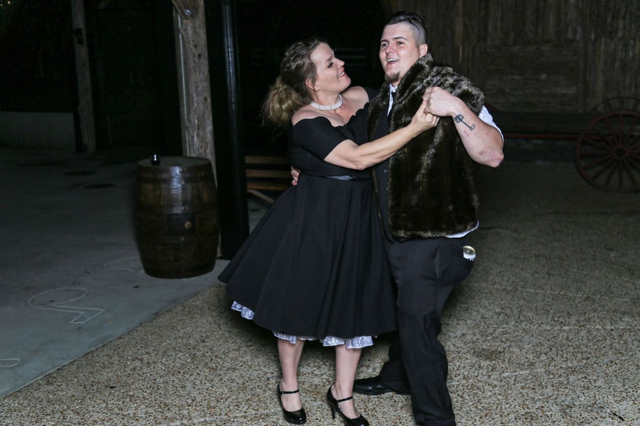 A couple dancing in a rustic barn hall